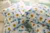 Blossoming Peonies Pillows from the Bee & Florals Collection are artfully arranged on a light couch. Their blue, green, and yellow floral print adds elegance and charm with Sewing Down South® craftsmanship as natural light streams in from a nearby window.