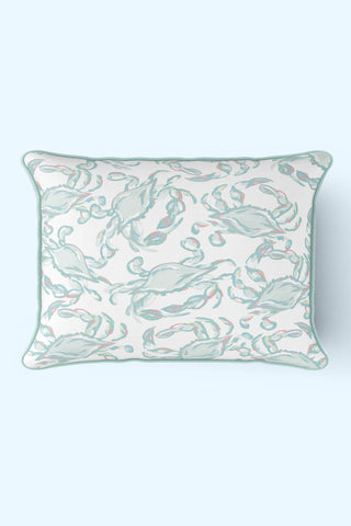 The Pastel Crab Craze Outdoor Lumbar Pillow, made with SDS Shield® Outdoor Fabric, features a Sewing Down South™ design of pastel pink and teal crabs on white, with a teal border on a light blue backdrop.